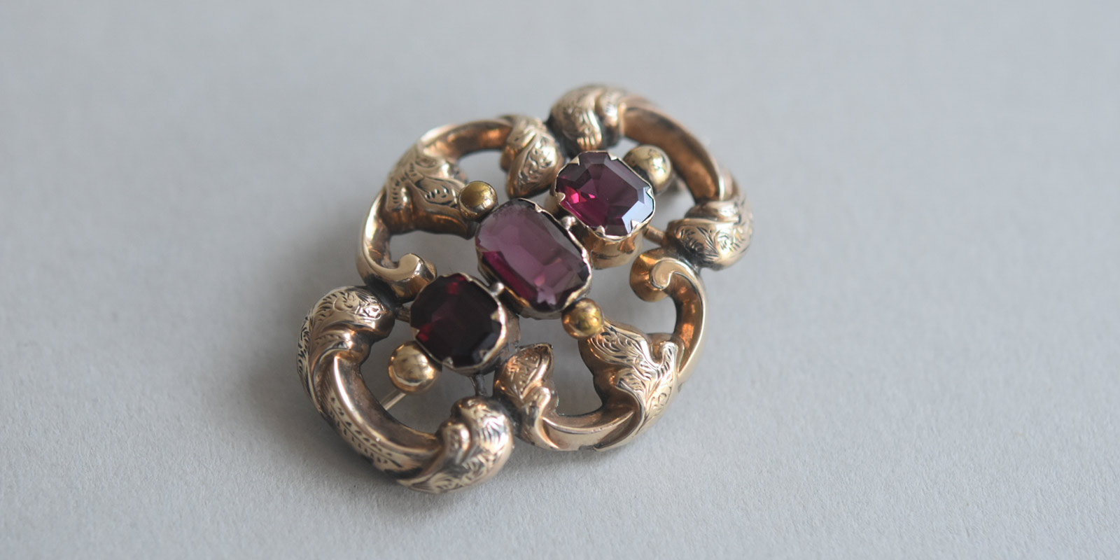 Mid Victorian florid 9ct gold brooch with pomegranate hue almandine ...