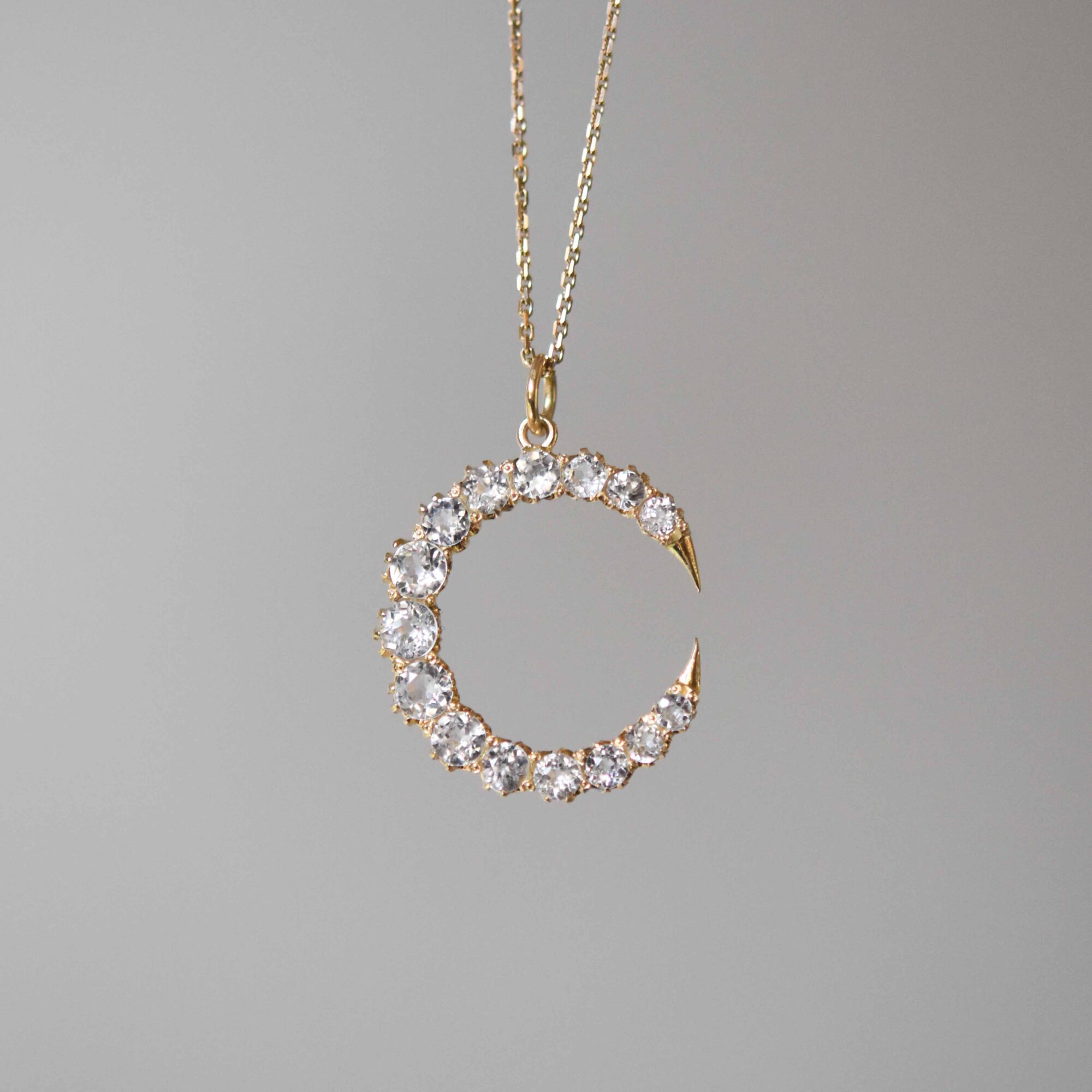 Antique 18ct gold white sapphire crescent pendant c.1920s