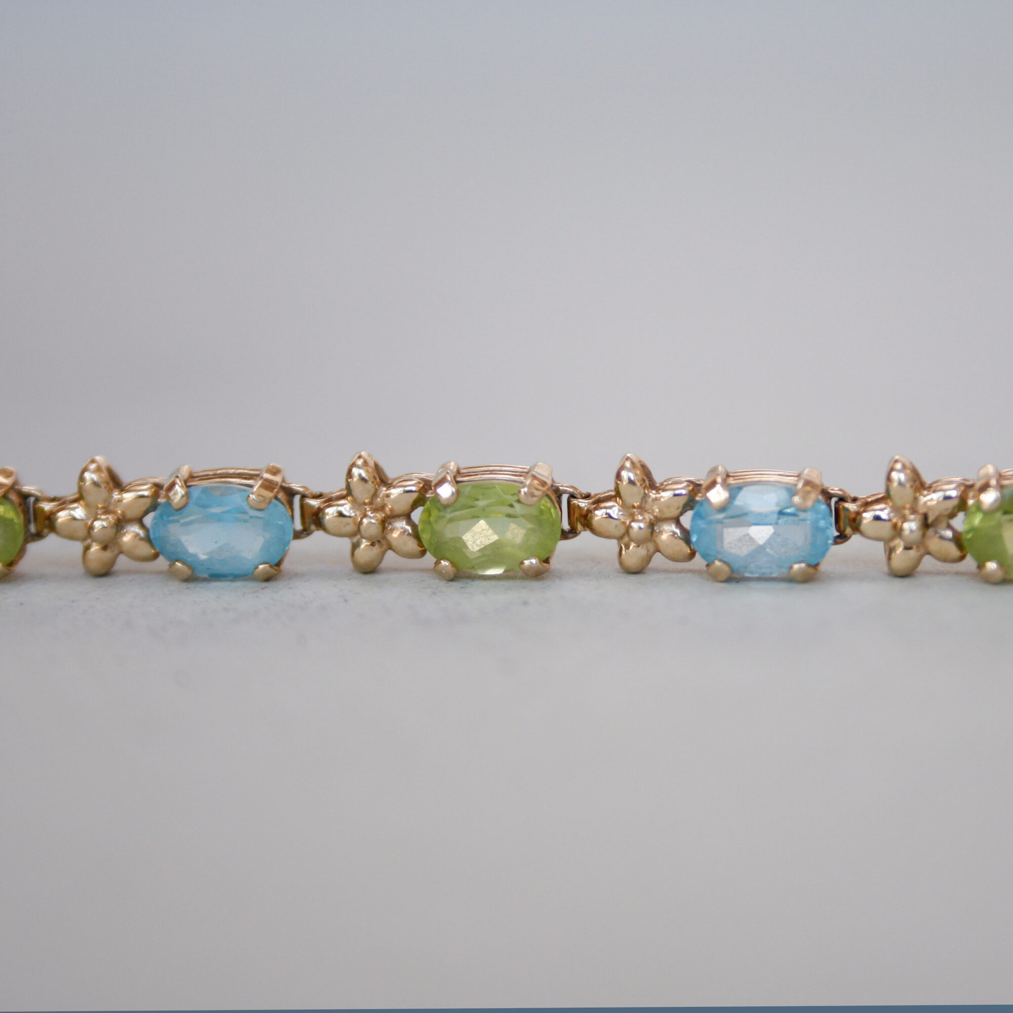 Contemporary 9ct gold blue topaz and peridot floral link bracelet - Image 4