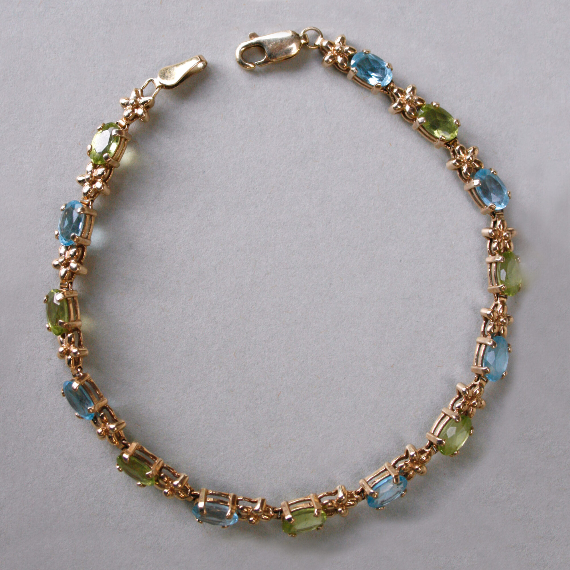 Contemporary 9ct gold blue topaz and peridot floral link bracelet