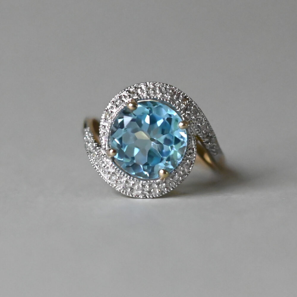 Contemporary 9ct gold blue topaz and mini diamond swirl ring